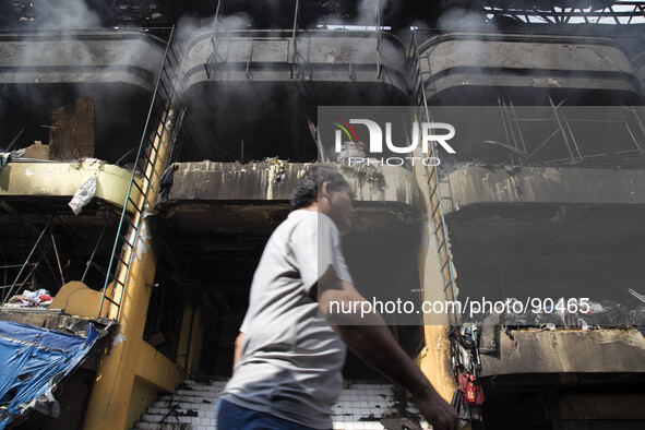 An owner of the kiosk that burn, passing by the fire place. The Senen Market in Central Jakarta was gutted by a fire on Friday morning. The...