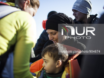 A woman reacts as refugees and migrants riding a dinghy reach the shores of the Greek island of Lesbos after crossing the Aegean Sea from Tu...
