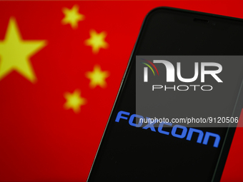 Foxconn logo displayed on a phone screen and Chinese flag displayed on a screen in the background are seen in this illustration photo taken...