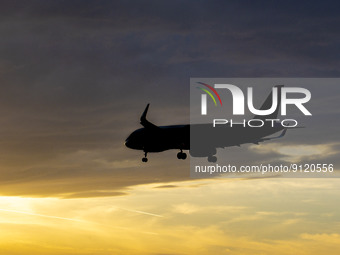 Aircraft silhouette, a symbol illustration photo during the magic hour of an arriving passenger plane for landing at Eindhoven Airport. Dusk...