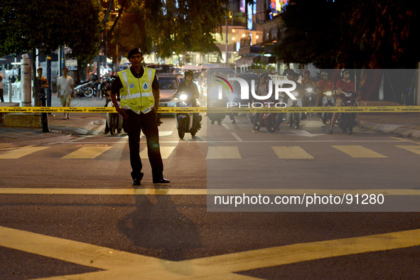 A Malaysian Police stands guard in front of the traffic as roads in Kuala Lumpur is in lockdown for the motorcade of U.S. President Barack O...