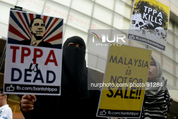 Malaysian Muslim women holds up play cards during a protest rally against Trans-Pacific Partnership Agreement (TPPA) ahead of U.S. President...
