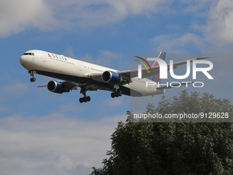 Delta Air Lines Boeing 767 aircraft as seen flying over Myrtle avenue during a summer day for landing at London Heathrow Airport LHR, a famo...
