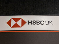 A logo at a HSBC bank. Night view of an HSBC UK - HSBC Holdings Plc Bank Branch in London with the logo bank. HSBC Holdings plc is a British...