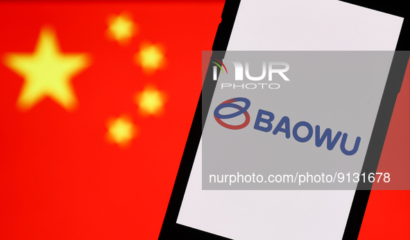 Baowu logo displayed on a phone screen and Chinese flag displayed on a screen in the background are seen in this illustration photo taken in...