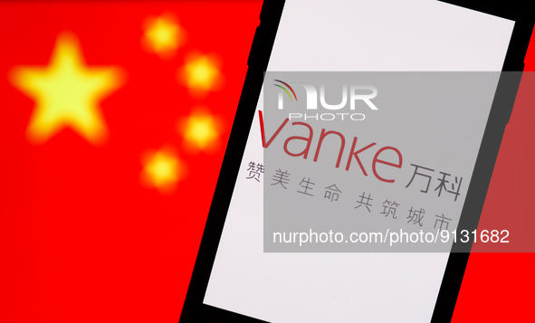 Vanke logo displayed on a phone screen and Chinese flag displayed on a screen in the background are seen in this illustration photo taken in...