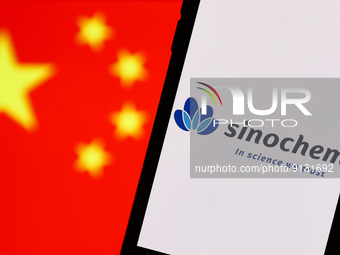 Sinochem logo displayed on a phone screen and Chinese flag displayed on a screen in the background are seen in this illustration photo taken...