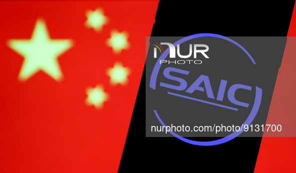 SAIC logo displayed on a phone screen and Chinese flag displayed on a screen in the background are seen in this illustration photo taken in...