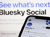 Bluesky Twitter account displayed on a phone screen and Bluesky Social website displayed on a screen in the background are seen in this illu...