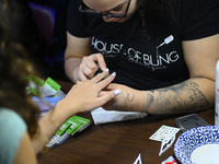 People get nail art with various Get Out The Vote messages at a pre-election Our Future is Now rally with U.S. Senator Bernie Sanders (I-VT)...