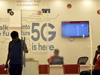 A man opens a door where 5G logo is written on a door of Airtel Store in Mumbai, India, 08 November, 2022. Within a month, Bharti Airtel cro...