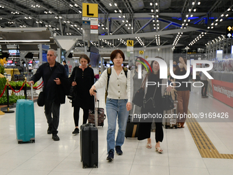 Travels seen carry their luggage inside the departure terminal of the Suvarnabhumi International Airport on November 9, 2022 in Sumut Prakan...