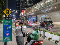 A motorcycle taxi drive on the main street  in Jakarta on 9 November 2022. According to the Coordinating Minister for Maritime Affairs and I...