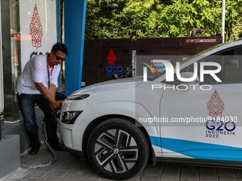 A worker charges an electric vehicle ahead of the G20 Summit in Nusa Dua, Bali, Indonesia, Saturday, Nov. 12, 2022. Indonesia will host the...
