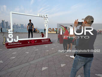 Football fans pose for pictures by the Corniche in Doha, Qatar on 12 November 2022, one week before the 2022 FIFA World Cup begins.  (