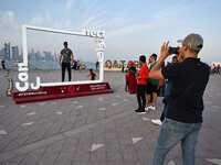 Football fans pose for pictures by the Corniche in Doha, Qatar on 12 November 2022, one week before the 2022 FIFA World Cup begins.  (