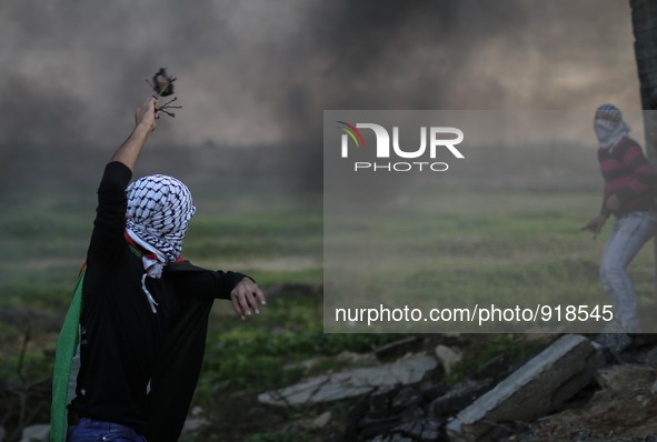 A Palestinian man uses a slingshot to launch stones at Israeli troops during clashes between Palestinians and Israeli troops along the borde...