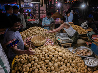 A vegetable seller sells potatoes to customers at a marketplace in Kolkata, on November 12, 2022. India's retail inflation, measured by the...
