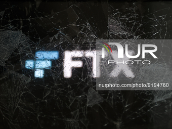 FTX logo displayed on a phone screen is seen through the broken glass in this illustration photo taken in Krakow, Poland on November 14, 202...