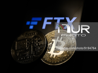 FTX logo displayed on a phone screen and representation of Bitcoin cryptocurrency are seen in this illustration photo taken in Krakow, Polan...