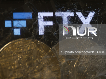 FTX logo displayed on a phone screen and representation of cryptocurrencies are seen through the broken glass in this illustration photo tak...