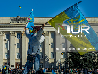 A woman shakes an ukrainian flag near the building of Kherson government after the liberation of the city by the ukrainian army of the russi...