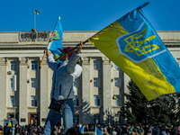 A woman shakes an ukrainian flag near the building of Kherson government after the liberation of the city by the ukrainian army of the russi...