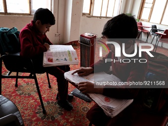 Students read inside a class room as heating facilities are installed in a private school in Baramulla Jammu and Kashmir India on 18 Novembe...