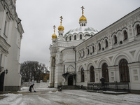 The woman cleanses the snow in the territory of Kyiv Pechersk Lavra, Ukraine, November, 2022 (