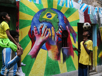 Brazil and Argentina supporters wearing favorite team  jersey playing football in front of an wall graffiti  to celebrate the Qatar 2022 FIF...