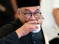 Malaysia's new Prime Minister, Anwar Ibrahim, sips a cup of coffee during his first press conference on November 24, 2022, at Kajang, Malays...