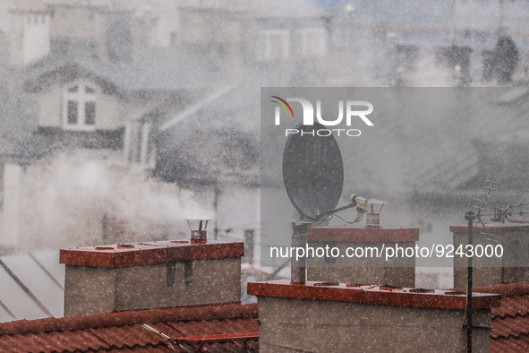 Smoke comes out of households' chimneys while the first snow is falling in Krakow, Poland, on November 24, 2022. Poland is one of the most p...