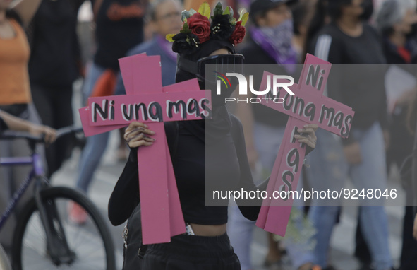 A member of the feminist Black Bloc holds two pink crosses in the Zócalo in Mexico City to mark the International Day for the Elimination of...