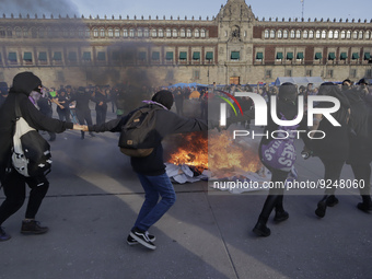 Members of the feminist Black Bloc burn banners and posters while demonstrating in Mexico City's Zócalo to mark the International Day for th...