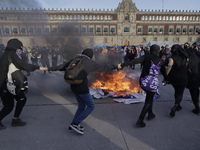Members of the feminist Black Bloc burn banners and posters while demonstrating in Mexico City's Zócalo to mark the International Day for th...