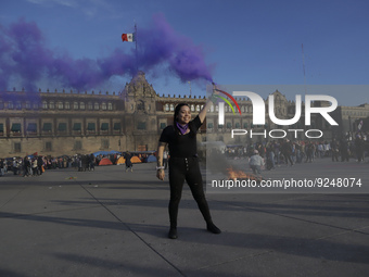 A member of the feminist Black Bloc burns a flare in the Zócalo in Mexico City to mark the International Day for the Elimination of Violence...