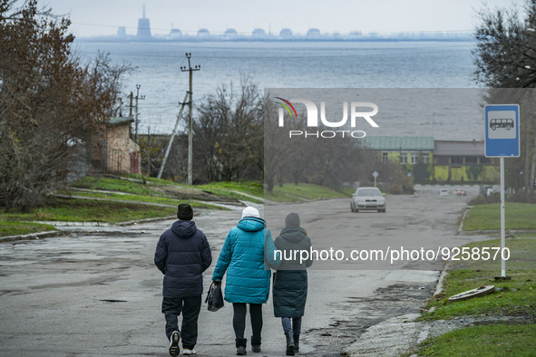 Streets of Nikopol city with the Zaporizhzhia NPP reactors in the background located in the left shore of the Dnipro river. The nuclear plan...