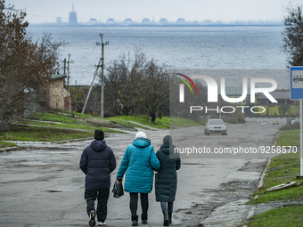 Streets of Nikopol city with the Zaporizhzhia NPP reactors in the background located in the left shore of the Dnipro river. The nuclear plan...