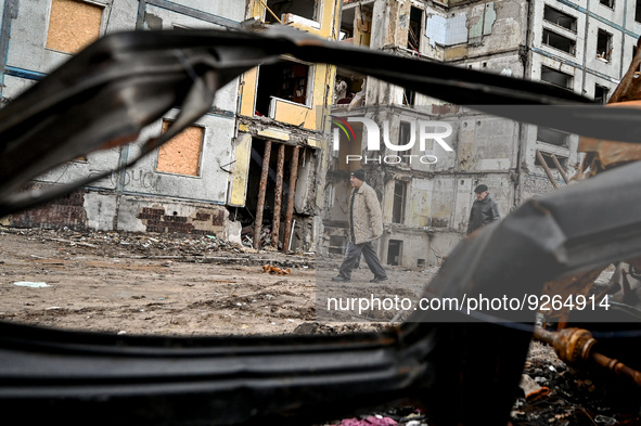ZAPORIZHZHIA, UKRAINE - NOVEMBER 22, 2022 - Men walk past an apartment building destroyed in the shelling of Russian troops, Zaporizhzhia, s...