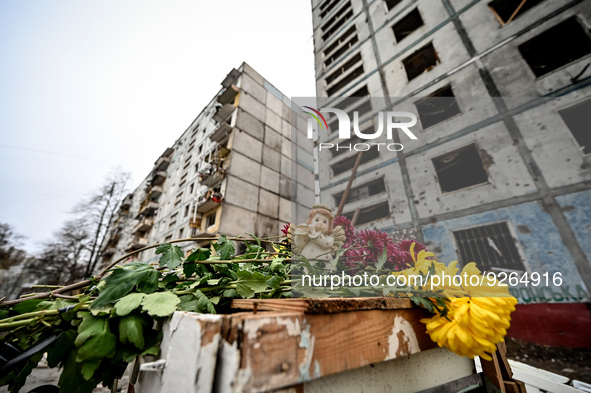 ZAPORIZHZHIA, UKRAINE - NOVEMBER 22, 2022 - A statuette of an angel and flowers lie outside an apartment building destroyed in the shelling...