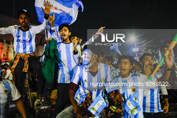 Football fans react as they watch the Qatar 2022 World Cup Group C football match between Argentina and Poland on a big screen, in the Dhaka...