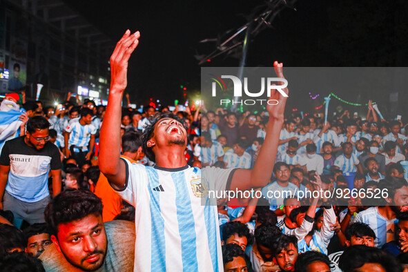 Football fans react as they watch the Qatar 2022 World Cup Group C football match between Argentina and Poland on a big screen, in the Dhaka...