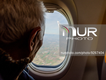 An elderly man is watching from the airplane window during the landing in a Ryanair Boeing 737 directed to Treviso A. Canova airport, on Nov...