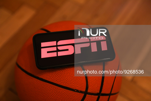 ESPN logo displayed on a phone screen and a basketball are seen in this illustration photo taken in Krakow, Poland on December 1, 2022. 