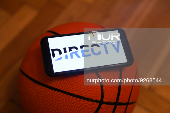 DIRECTV logo displayed on a phone screen and a basketball are seen in this illustration photo taken in Krakow, Poland on December 1, 2022. 