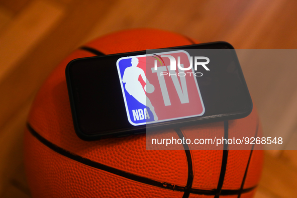 NBA TV logo displayed on a phone screen and a basketball are seen in this illustration photo taken in Krakow, Poland on December 1, 2022. 