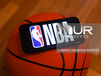 NBA logo displayed on a phone screen and a basketball are seen in this illustration photo taken in Krakow, Poland on December 1, 2022. (