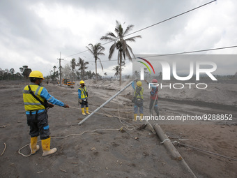 
Officers inspect the power grid affected by the hot clouds of the Mount Semeru eruption in Kajar Kuning Hamlet, Sumberwuluh Village, Lumaj...