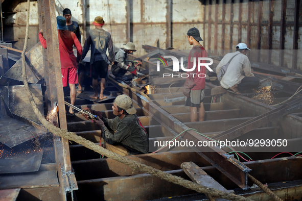 Myanmar workers work at a ship demolition site near Dala jetty in Yangon on December 7, 2022. 