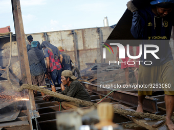 Myanmar workers work at a ship demolition site near Dala jetty in Yangon on December 7, 2022. (